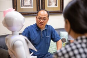 Xiaopeng Zhao pictured with FRED robot